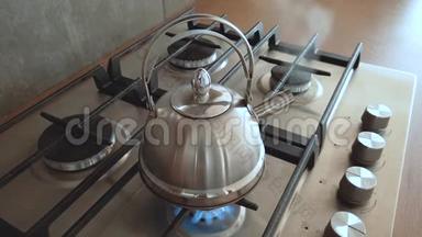 在家用煤气炉上烧开钢金属水壶，家庭用开水煮茶室内蒸汽